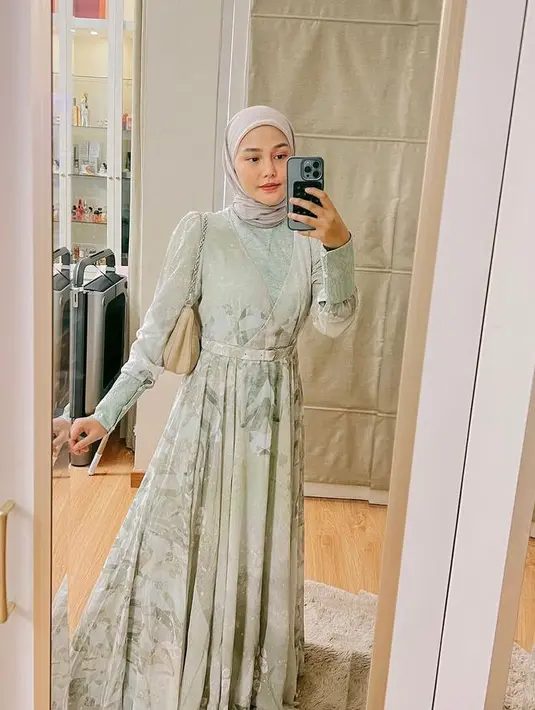 Dara Arafah juga mengenakan gamis berwarna sage green dipadu hijab warna light grey untuk tampilan yang lebih fresh. Penampilannya ini disempurnakan dengan shoulder bag warna nude. (Instagram/daraarafah).