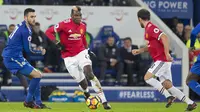 Gelandang Manchester United, Paul Pogba, berusaha melewati gelandang Leicester City, Vicente Iborra, pada laga Premier League di Stadion King Power, Minggu (24/12/2017). Kedua tim bermain imbang 2-2. (AFP/Roland Harrison)