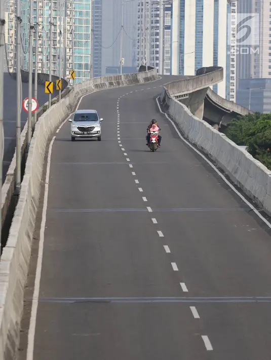 Sejumlah kendaraan melintas di Jalan Thamrin, Jakarta, Jumat (15/6). Pada Hari Raya Lebaran hari pertama, sejumlah ruas jalan di Jakarta tampak sepi dan lengang, berbeda dengan kondisi normal yang padat dan macet. (Liputan6.com/Arya Manggala)