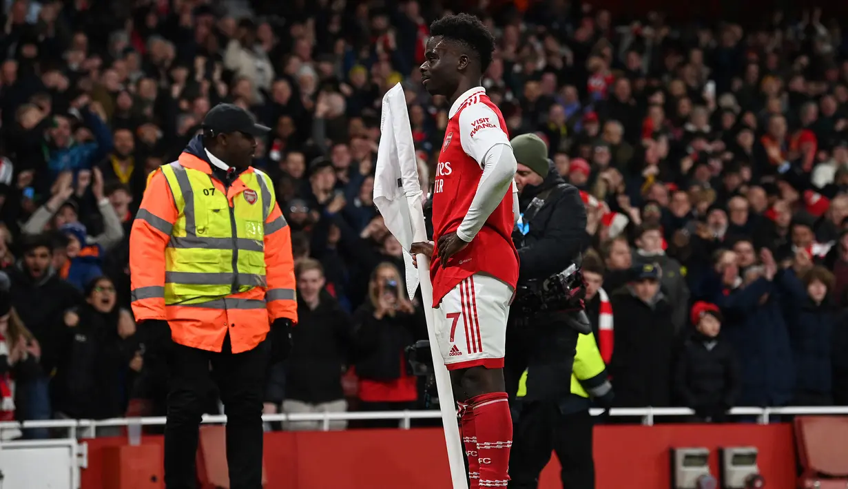 Selebrasi gelandang Arsenal, Bukayo Saka setelah menjebol gawang Everton pada laga Liga Inggris 2022/2023 di Emirates Stadium, London (1/3/2023). Bukayo Saka makin menunjukkan permainan impresif di lini tengah Arsenal sejak dipromosikan dari tim U-23 pada awal musim 2019/2020. Musim 2022/2023 ini ia telah mencetak 10 gol dan 9 assist dari total 27 laga di Liga Inggris. Namun ia hanya menerima gaji sebesar 33 ribu pound sterling atau setara Rp614 juta per pekan. (AFP/Glyn Kirk)
