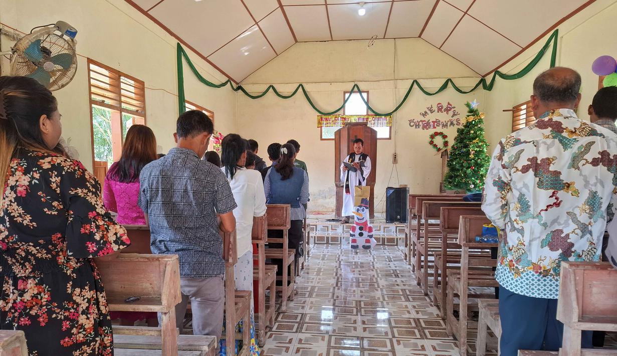 Puluhan jemaat tetap khidmat menyanyikan himne dalam misa Natal, ini menjadi ibadah pertama mereka sejak banjir dan tanah longsor. Tampak dalam foto, warga desa menghadiri Misa Natal di Gereja Protestan Angkola di desa Aek Ngadol, Tapanuli Selatan, Sumatera Utara, pada Kamis 25 Desember 2025, setelah banjir dan tanah longsor yang melanda di daerah tersebut pada akhir November 2025 lalu. (AMROE/AFP)