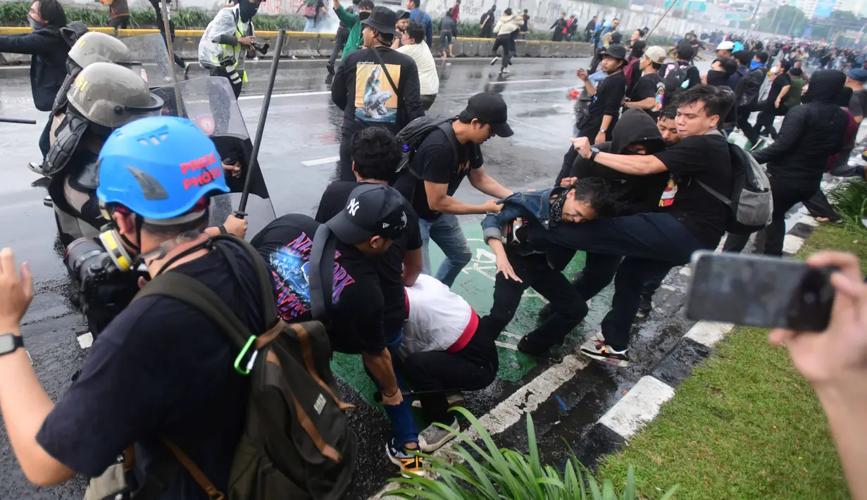 Dipukul mundur, massa mencoba bertahan dengan melempari anggota polisi dengan batu. (merdeka.com/Arie Basuki)