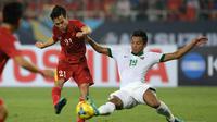 Nguyen Van Toan (kiri) berebut bola dengan Bayu Pradana. Indonesia imbang 2-2 dengan Vietnam dan berhak lolos ke partai final Piala AFF 2016. (HOANG DINH NAM / AFP)