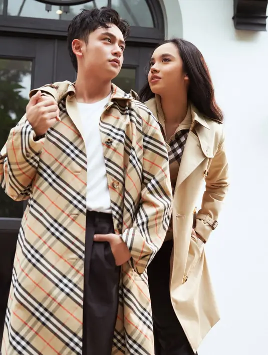 Randy Martin tampil stylish dengan t-shirt putih berbalut trench coat monogram Burberry [@randymartinnn]