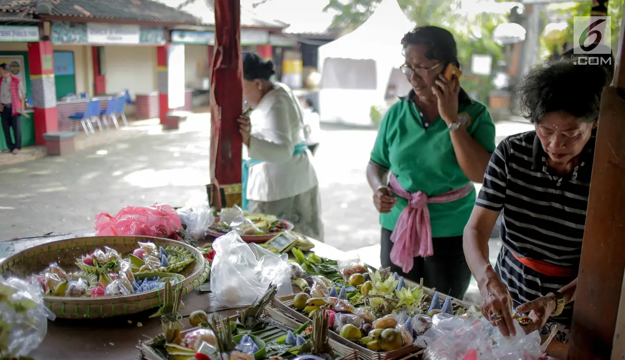 Sejumlah ibu-ibu membuat berbagai macam sesajen untuk persiapan menyambut Hari Raya Nyepi 2019 pada Tahun Baru Saka di Pura Aditya Jaya, Rawamangun, Jakarta, Senin (4/3). (Liputan6.com/Faizal Fanani)