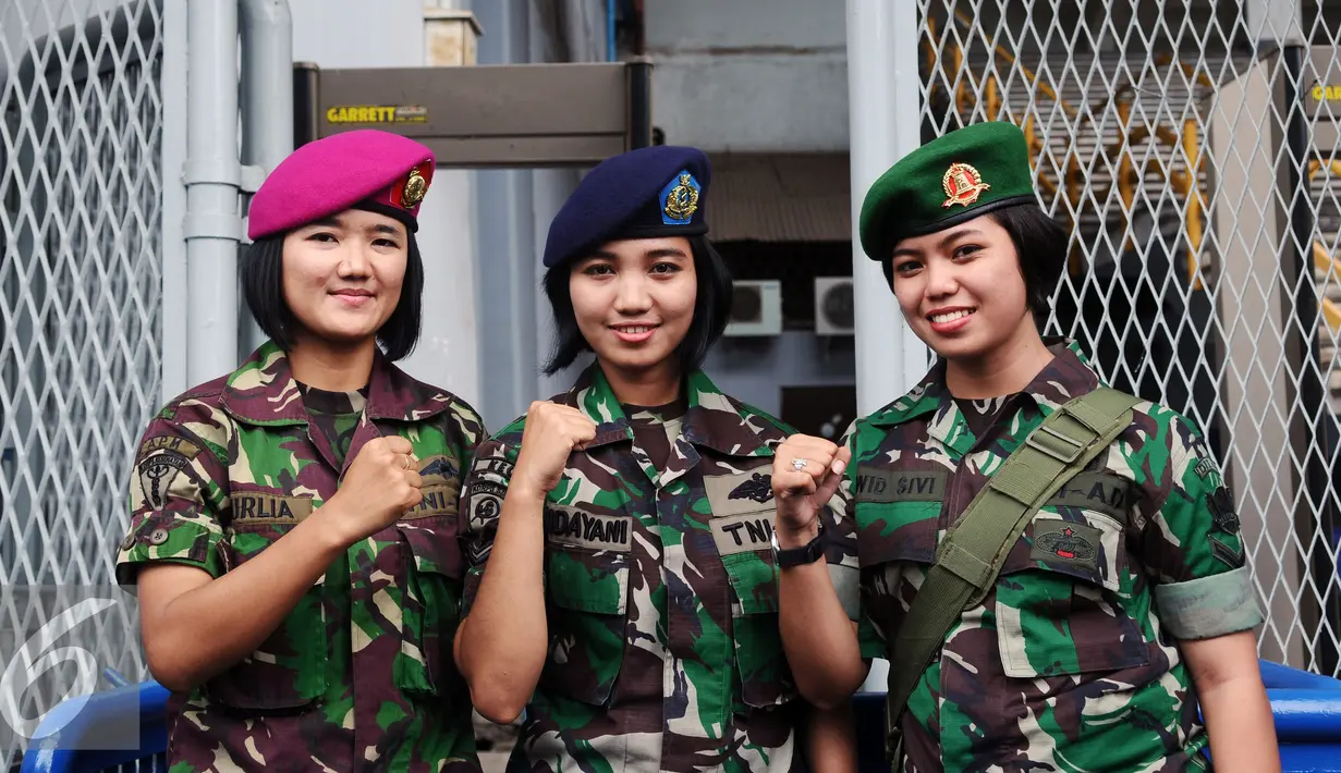 Tiga prajurit wanita TNI berpose di depan gerbang masuk Stadion GBK Jakarta, Minggu (24/1/2016). TNI mengerahkan prajurit wanita untuk memberi rasa aman dan nyaman bagi para suporter perempuan. (Liputan6.com/Helmi Fithriansyah)