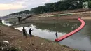 Seorang anak berfoto di penyaring sampah yang dijadikan jembatan di Kanal Banjir Timur di Jakarta, Kamis (28/12). Penyaring sampah yang berupa pelampung tersebut dimanfaatkan warga sebagai sarana untuk menyeberang. (Liputan6.com/Immanuel Antonius)