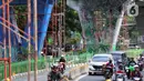 Pengendara melintas dekat dinding Jalan Layang Pesing yang berhias mural di Jakarta Barat, Sabtu (7/12/2019). Mural pada jalan layang sepanjang 1,5 kilometer tersebut merupakan bagian dari program Pemerintah Provinsi DKI Jakarta dalam mempercantik Ibu Kota. (Liputan6.com/Johan Tallo)