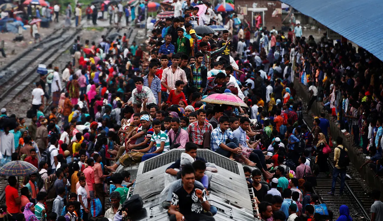 Ribuan orang tampak berdesakan menaiki atap kereta yang sudah penuh sesak di sebuah stasiun, Dhaka, Bangladesh, (5/7).Tradisi mudik yang dilakukan warga Bangladesh ini dilakukan tiap tahunnya untuk merayakan Hari Raya Idul Fitri. (REUTERS / Adnan Abidi)