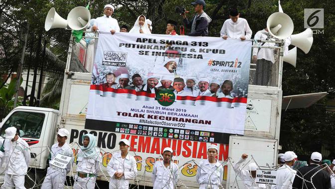 Massa Forum Umat Islam berorasi saat mengikuti kegiatan 'Apel Siaga Umat untuk Pemilu Bersih, Jujur, dan Adil' di depan Kantor KPU, Jakarta, Minggu (31/3). Dalam aksinya, massa menolak segala bentuk kecurangan dalam Pemilu yang akan berlangsung 17 April mendatang. (Liputan6.com/Immanuel Antonius)