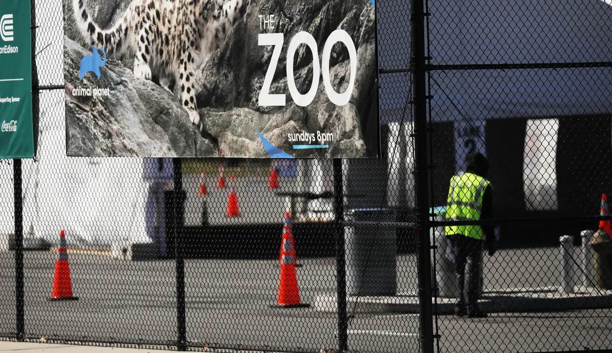 Seorang penjaga berdiri di pintu masuk ke Kebun Binatang Bronx di New York City, Amerika Serikat, Senin (6/4/2020). Kebun Binatang Bronx sebetulnya sudah ditutup sejak 16 Maret lalu guna mencegah penyebaran virus corona COVID-19. (Spencer Platt/Getty Images/AFP)