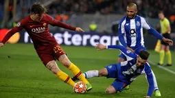 Gelandang AS Roma Nicolo Zaniolo (kiri) menggiring bola melewati bek FC Porto Alex Telles saat bertanding pada babak 16 besar Liga Champions di Stadion Olimpico, Roma, Italia, Selasa (12/2). Nicolo berhasil mencetak dua gol. (AP Photo/Andrew Medichini)