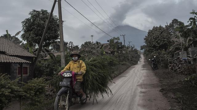 <span>Gunung Semeru menjulang sehari setelah erupsi di atas desa Lumajang, Jawa Timur, pada Minggu (17/1/2021). Kendati demikian, Pusat Vulkanologi dan Mitigasi Bencana Geologi ( PVMBG) menegaskan status Semeru masih level II atau Waspada. (Juni Kriswanto / AFP)</span>
