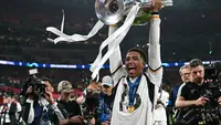 Momen Jude Bellingham angkat trofi juara Liga Champions 2023/2024. (Paul ELLIS / AFP)