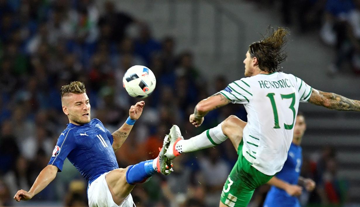 Pemain Irlandia, Jeffrey Hendrick (kanan), berebut bola dengan pemain Italia, Ciro Immobile, pada laga Grup E Piala Eropa 2016 di Stade Pierre Mauroy, Lille, Kamis (23/6/2016) dini hari WIB. (AFP/Philippe Lopez)