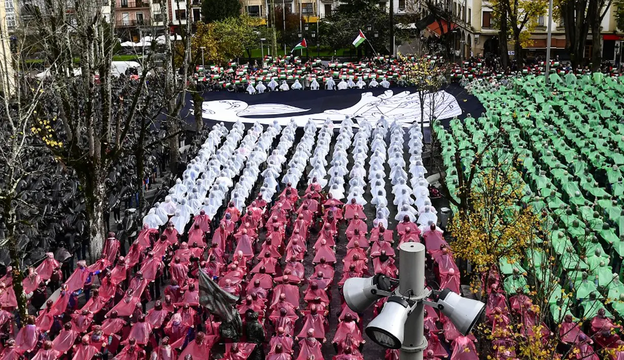 Menurut laporan Anadolu Agency, pada acara yang diselenggarakan di Kota Guernica, orang-orang membuat mosaik dengan rantai manusia yang menggambarkan penderitaan para korban serangan Israel di Gaza dan bendera Palestina. (ANDER GILLENEA/AFP)