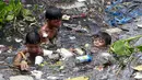 Sejumlah anak memilah sampah yang terapung untuk di jadikan bahan daur ulang di sebuah sungai yang tercemar di kota navotas, Manila, Kamis (2/7/2015). Daur ulang bertujuan untuk mengurangi tingkat pencemaran sungai. (REUTERS/Romeo Ranoco)