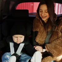 ibu sedang memasangkan car seat untuk anaknya. credits: freepik