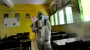 Petugas Palang Merah Indonesia (PMI) melakukan penyemprotan disinfektan di SMPN 216 Jakarta, Senin (16/3/2020). Mulai hari ini, aktivitas sekolah di sejumlah wilayah Indonesia diliburkan untuk mengantisipasi penyebaran virus corona COVID-19. (merdeka.com/Arie Basuki)