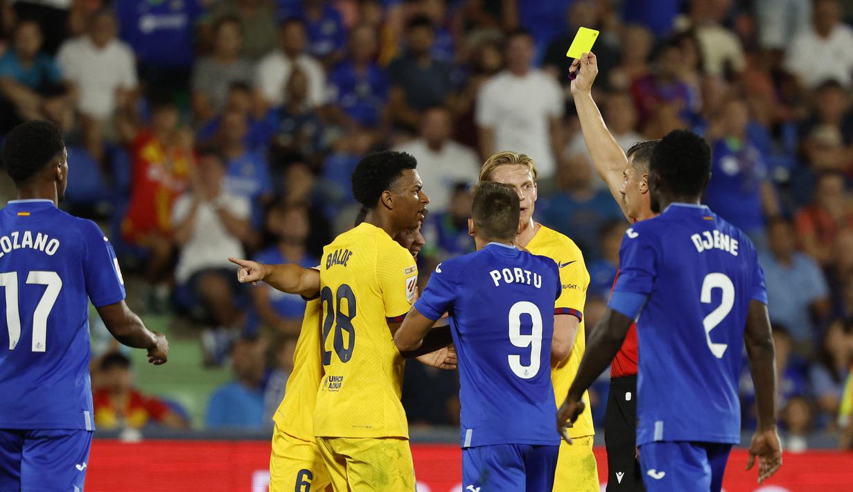 Wasit Cesar Soto Grado memberikan kartu kuning kepada pemain Barcelona, Gavi setelah melakukan pelanggaran kepada pemain Getafe saat laga pekan pertama Liga Spanyol 2023/2024 melawan Getafe di Coliseum Alfonso Perez Stadium, Getafe, Spanyol, 14 Agustus 2023 WIB. (AFP/Javier Soriano)
