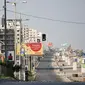 Warga Palestina berjalan di jalan sepi di tepi pantai pada awal pemberlakukan lockdown total selama 48 jam di Kota Gaza, Selasa (25/8/2020). Lockdown dan jam malam diberlakukan di wilayah jalur Gaza menyusul terkonfirmasinya kasus Covid-19 pertamanya di sebuah kamp pengungsian. (MOHAMMED ABED/AFP)