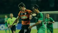 Penyerang Persebaya Surabaya Rishadi Fauzi (kanan) coba melewati bek Perseru Serui Atanya Geldiyew. (Dok Persebaya)