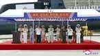 Gambar ini diambil pada tanggal 6 September 2023 dan dirilis oleh Korean Central News Agency (KCNA) pada tanggal 8 September 2023 menunjukkan Pemimpin Korea Utara Kim Jong Un (tengah) saat peluncuran "kapal selam serang nuklir taktis" No. 841 di lokasi yang dirahasiakan di Korea Utara. (STR/KCNA VIA KNS/AFP)