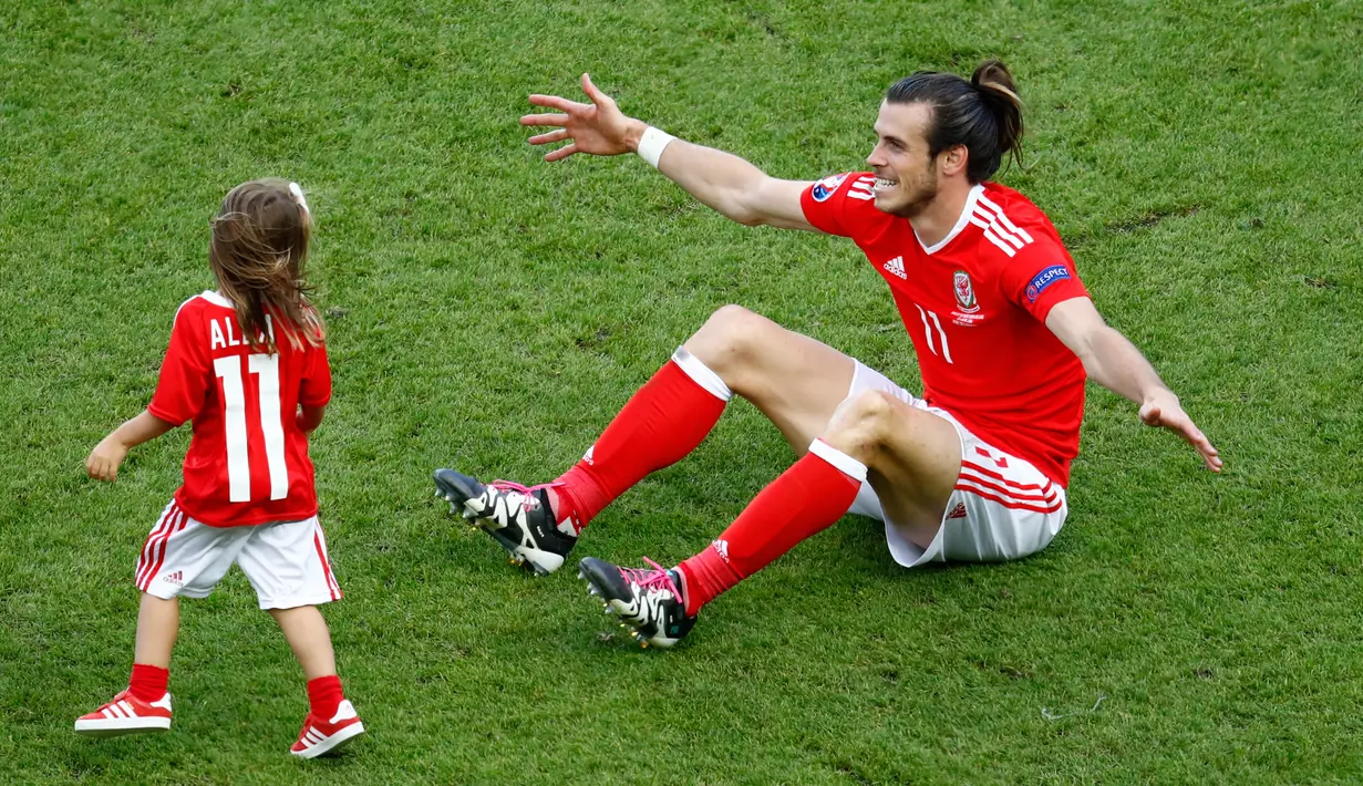 Gareth Bale bersama putrinya, Alba usai laga melawan Irlandia Utara dalam babak 16 besar Euro 2016 di Parc des Princes, Paris, Prancis, Minggu (26/6). (REUTERS/ Christian Hartmann)