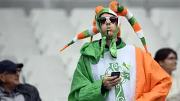 Suporter Irlandia memakai kostum unik menunggu pertandingan Euro 2016 grup E antara Irlandia melawan Swedia di Stadion Stade de France, Saint-Denis, Prancis, (13/6). (AFP PHOTO/MARTIN BUREAU)