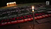 Syal gabungan suporter klub sepak bola dalam aksi lilin terkait solidaritas tragedi teror bom di Surabaya dan Sidoarjo di Taman Suropati, Jakarta, Senin (14/5). (Liputan6.com/Immanuel Antonius)