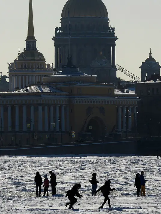 Sejumlah warga orang berjalan di Sungai Neva yang beku di St.Petersburg, Rusia, (4/3). Suhu di kota terbesar kedua Rusia tersebut telah mencapai 10 derajat celcius. (AFP Photo/Olga Maltseva)