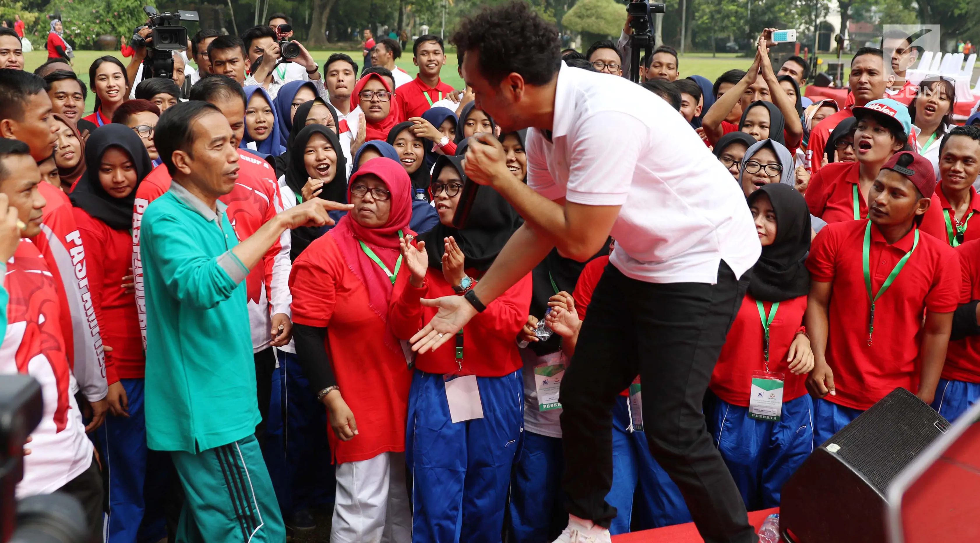 Presiden Joko Widodo ikut bernyanyi saat menonton penampilan Giring Nidji di halaman Istana Bogor, Jawa Barat, Sabtu (12/8). Giring tampil usai mengikuti peluncuran Program Penguatan Pendidikan Pancasila. (Liputan6.com/Angga Yuniar)