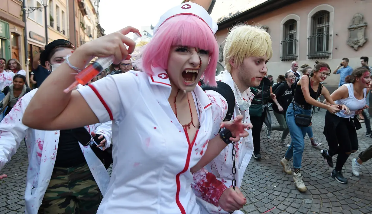 Warga memakai kostum dan dandanan menyerupai zombie saat acara Zombie Walk di kota Strasbourg, Prancis, 15 September 2018. Acara ini dalam rangka Festival Film Fantasi Eropa ke-11 yang berlangsung dari 14 hingga 23 September. (FREDERICK FLORIN/AFP)