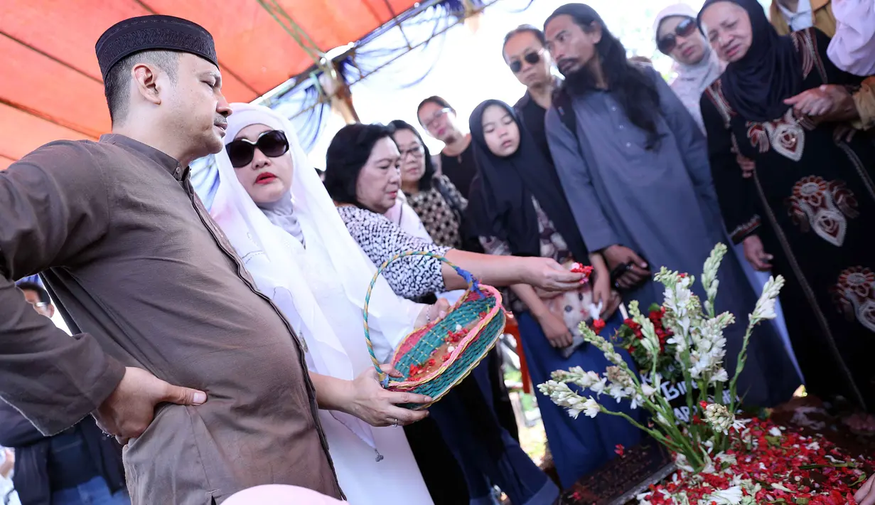 Dengan mengenakan celana, peci hitam, serta baju koko cekelat Adi Bing Slamet ikut turun ke liang lahat. Aktor senior itu juga mengumandangkan iqomah sebelum akhirnya jenazah diurung dengan tanah.  (Nurwahyunan/Bintang.com)