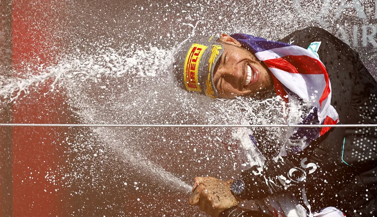 Pembalap Mercedes, Lewis Hamilton merayakan kemenangannya di Formula 1 GP Inggris 2024 yang berlangsung di Sirkuit Silverstone, Inggris, Minggu (08/07/2024). (AFP/Benjamin Cremel)