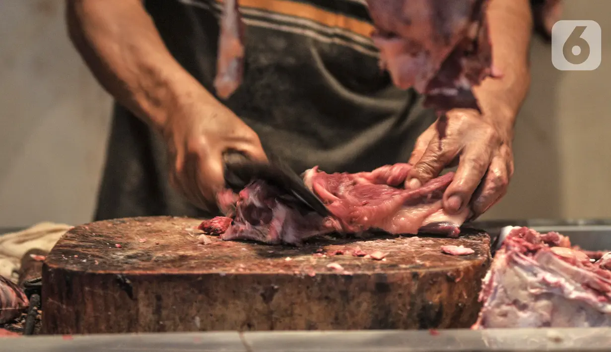 Pedagang memotong daging sapi di Pasar Senen, Jakarta Pusat, Selasa (31/5/2022). Maraknya kasus penyakit mulut dan kuku (PMK) pada hewan ternak seperti sapi dan kambing sejak beberapa waktu lalu, serta ditambah masih tingginya harga berimbas pada merosotnya penjualan daging di Pasar Senen hingga 50 persen. (merdeka.com/Iqbal S. Nugroho)