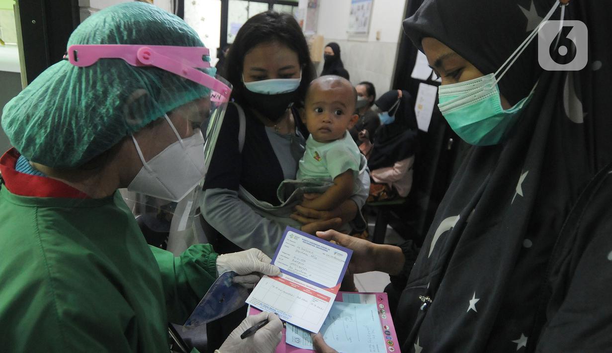 Petugas memberikan kartu vaksinasi kepada ibu hamil setelah disuntik vaksin covid-19 Sinovac di Puskesmas Jagakarsa II, Jakarta Selatan, Kamis (19/08/2021). Sudah dari pekan lalu sejumlah Puskesmas di DKI membuka vaksinasi covid-19 bagi ibu hamil. (merdeka.com/Arie Basuki)