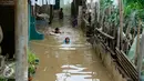 Anak-anak gang H. Maliki, Cawang memanfaatkan banjir untuk berenang, Jakarta, Senin (16/11). Pasca datangnya air kiriman dari Bogor, puluhan rumah di pinggir kali Ciliwung terendam banjir dengan ketinggian mencapai 3 meter. (Liputan6.com/Yoppy Renato)