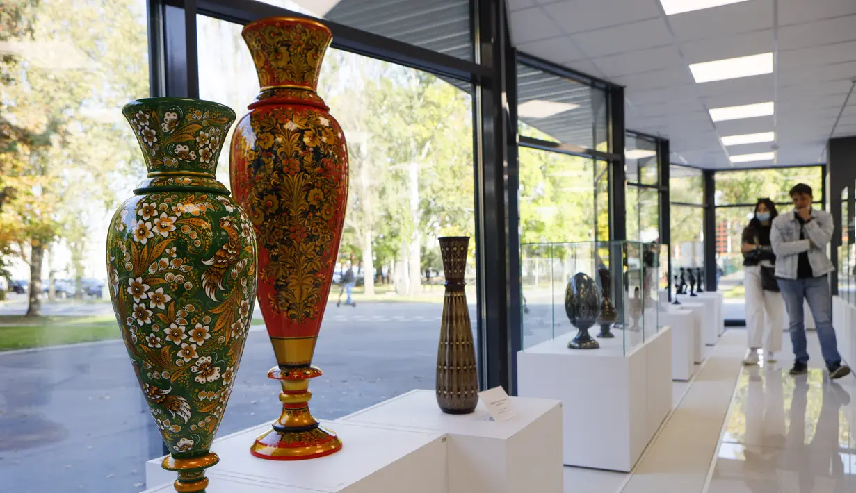 Orang-orang yang memakai masker mengunjungi pameran kesenian rakyat tradisional Rusia di Moskow, Rusia, 4 Oktober 2020. Lebih dari 1.000 karya seni tradisional Rusia buatan produsen kerajinan terkemuka dipamerkan di acara tersebut. (Xinhua/Alexander Zemlianichenko Jr)