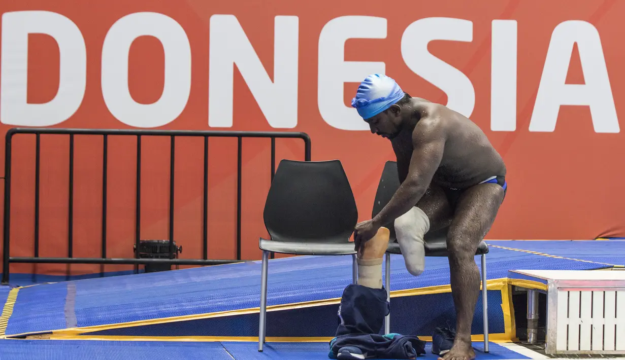 Perenang India, Mukundan Niranjan, memakai kaki palsu usai tampil pada nomor 50 meter gaya bebas di Stadion Aquatic, Stadion Aquatic Senayan, Jakarta, Minggu (7/10/2018). (Bola.com/Vitalis Yogi Trisna)