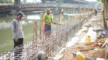 Pekerja menyelesaikan pembuatan turap Kali Ancol di Jakarta Utara, Minggu (15/12/2019). Dinas Sumber Daya Air Pemprov DKI melakukan penataan turap Kali Ancol sebagai bagian dari program pengendali banjir yang nantinya juga akan digunakan sebagai jalur pedestrian. (Liputan6.com/Immanuel Antonius)