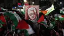 Warga Palestina membawa bendera nasional dan foto Presiden Mahmud Abbas saat menunggu live-screening pidato Presiden mereka sebelum pengibaran bendera Palestina di markas besar PPB di New York, Rabu (30/9/2015). (AFP PHOTO/ABBAS Momani)