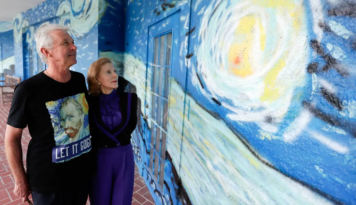 Nancy Nemhauser dan Lubomir Jastrzebski berpose dekat mural di rumah mereka di Florida, 18 Juli 2018. Pada Februari  2018, pasangan suami istri  itu menggugat kota karena dinilai melanggar hak konstitusional mereka untuk bebas berekspresi. (AP/John Raoux)
