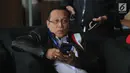 Dirut PT Kereta Api Indonesia Edi Sukmoro bermain ponsel di lobi gedung KPK, Jakarta, Senin (12/08/2019). Edi Sukmoro tampil mengenakan jaket kulit hitam dan sepatu sneakers saat ingin bertemu pempinan KPK  untuk melakukan konsultasi pencegahan tindak pidana korupsi. (merdeka.com/Dwi Narwoko)