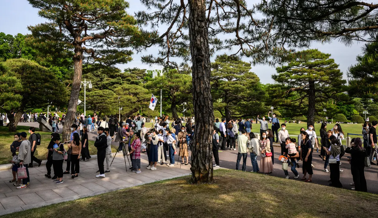 Pengunjung berbaris untuk mengambil foto di Kompleks Blue House sehari setelah dibuka untuk umum menyusul janji kampanye Presiden Korea Selatan Yoon Suk-yeol di Seoul, Korea Selatan, 11 Mei 2022. (ANTHONY WALLACE/AFP)