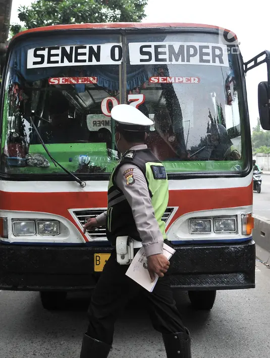 Polisi memberhentikan Metromini yang melintasi jalur bus Transjakarta di Jalan Yos Sudarso, Jakarta, Senin (21/1). Razia rutin ini digelar untuk menjaring pengendara yang nekat menerobos jalur bus Transjakarta. (Merdeka.com/Iqbl Nugroho)