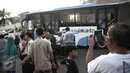 Warga mengambil gambar bus TransJakarta usai ditabrak kereta api Senja Utama Solo di perlintasan kereta Mangga Dua, Jakarta, Kamis (19/5). Selain menabrak bus TransJakarta, KA Senja Utama Solo juga menabrak mobil Avanza. (Liputan6.com/Faizal Fanani)