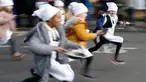 Anak-anak sekolah-sekolah lokal mengambil bagian dalam lomba lari sembari membawa wajan berisi pancake di Olney, Buckinghamshire, Inggris, Selasa (25/2/2020). Peserta kompetisi yang sudah ada sejak tahun 1445 ini harus membolak-balikan pancake sambil tetap berlari. (AP/Alastair Grant)