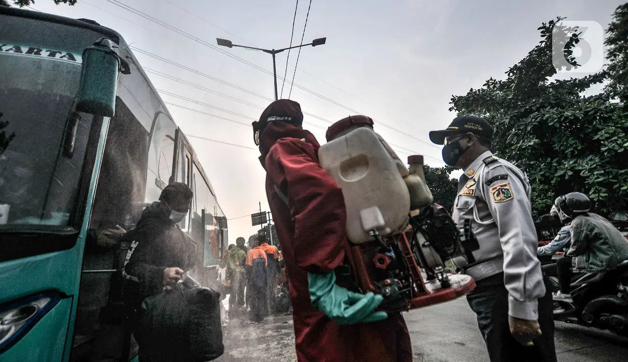 Petugas pemadam kebakaran wilayah Kecamatan Ciracas saat menyemprotkan disinfektan kepada penumpang bus AKAP yang baru tiba di Terminal Kampung Rambutan, Jakarta, Minggu (23/5/2021). (merdeka.com/Iqbal S Nugroho)