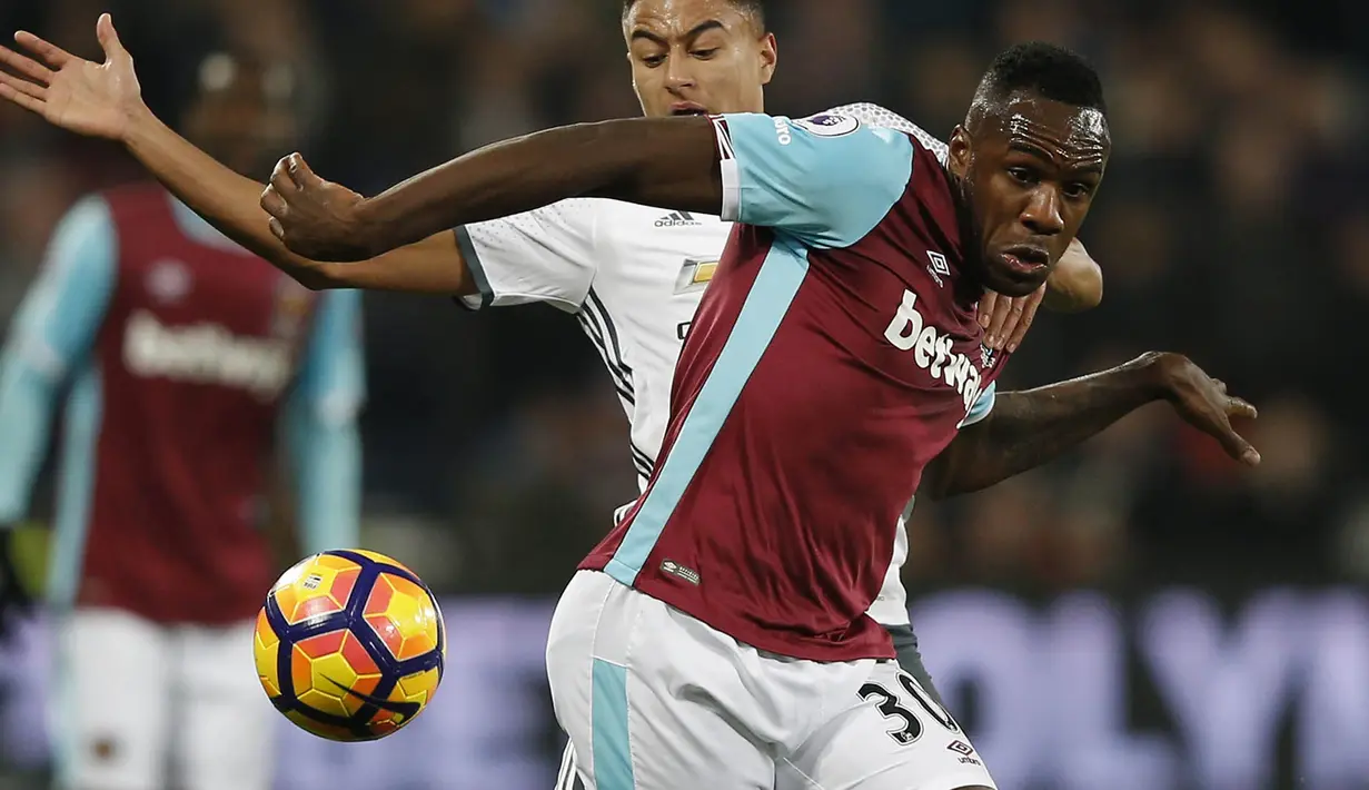 Penyerang West Ham, Michail Antonio, berebut bola dengan gelandang Manchester United, Jesse Lingard, pada laga Liga Inggris di Stadion London, Inggris, Senin (2/1/2017). West Ham kalah 0-2 dari MU. (AFP/Adrian Dennis)
